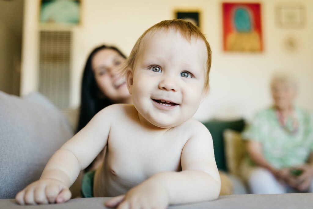 Young toddler boy smiling bashfully at the camera in the living room