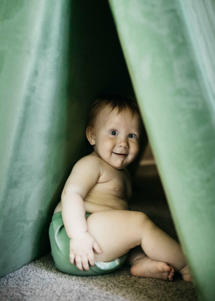 toddler playing hide and go seek in seat cushions