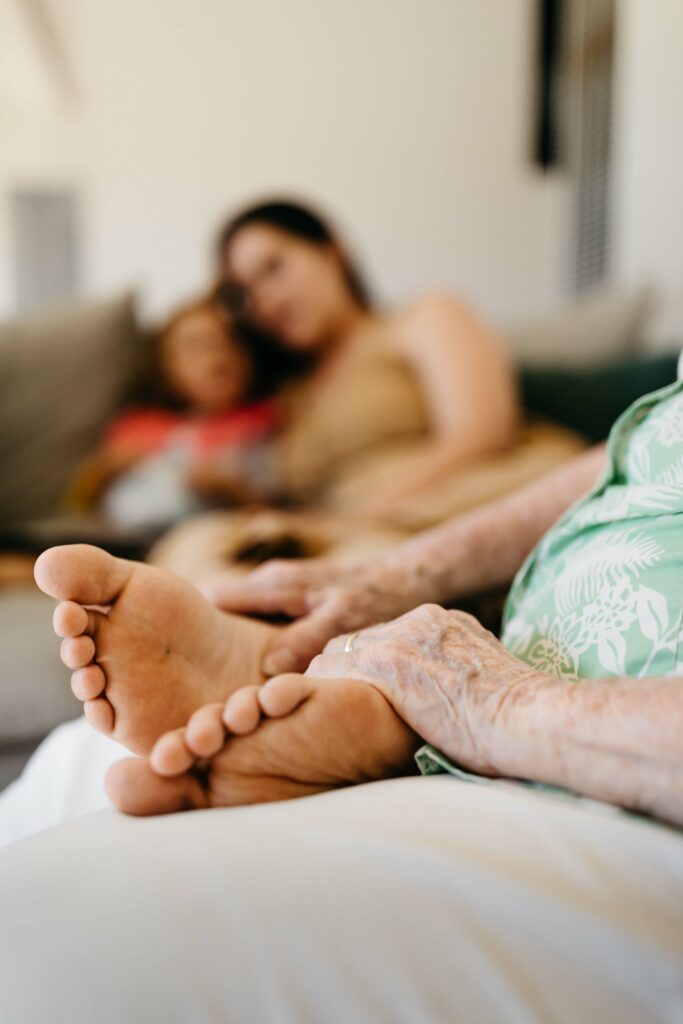 grandmother tenderly holding onto her grandchild's feet