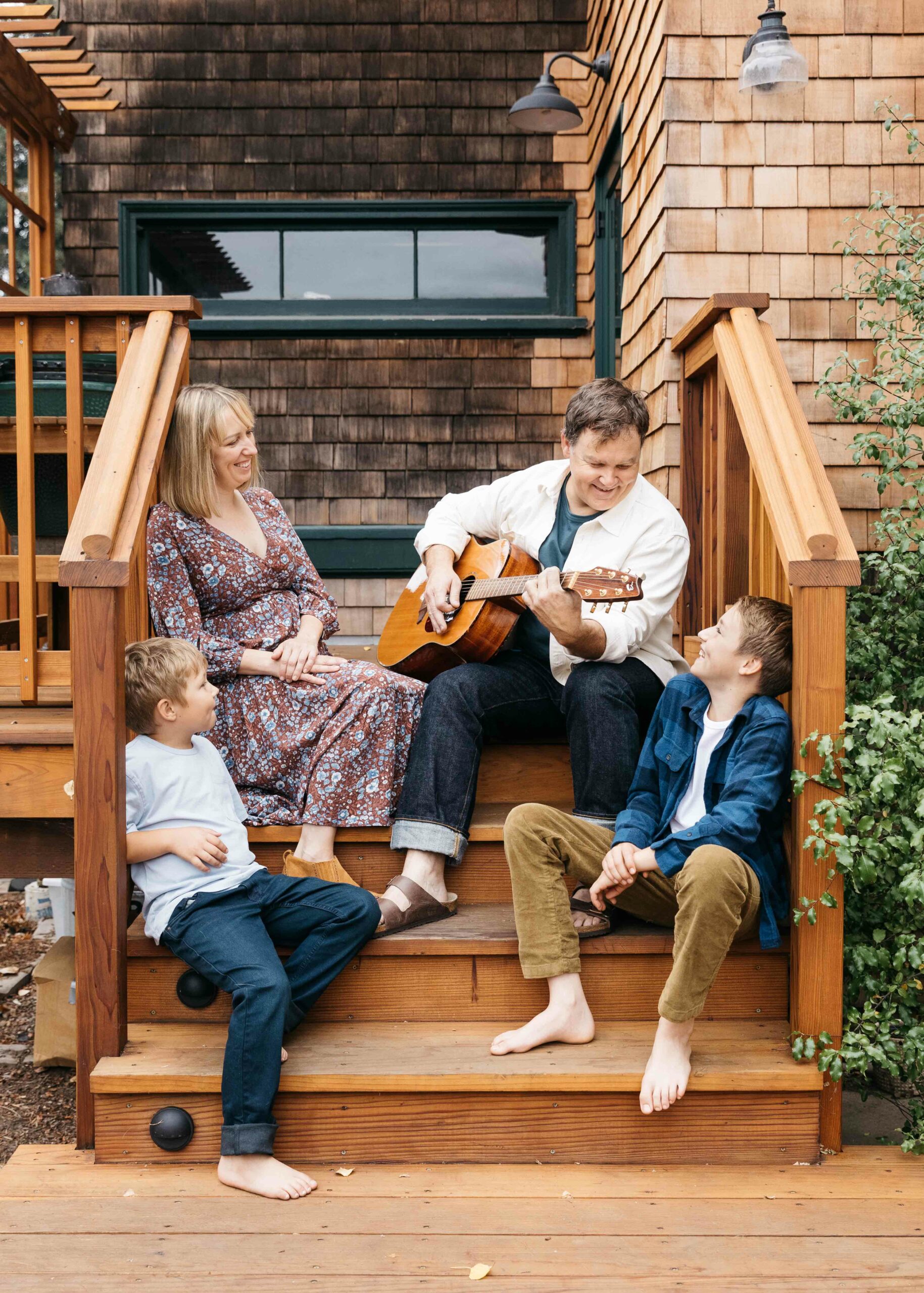 Family playing guitar on the backyard patio