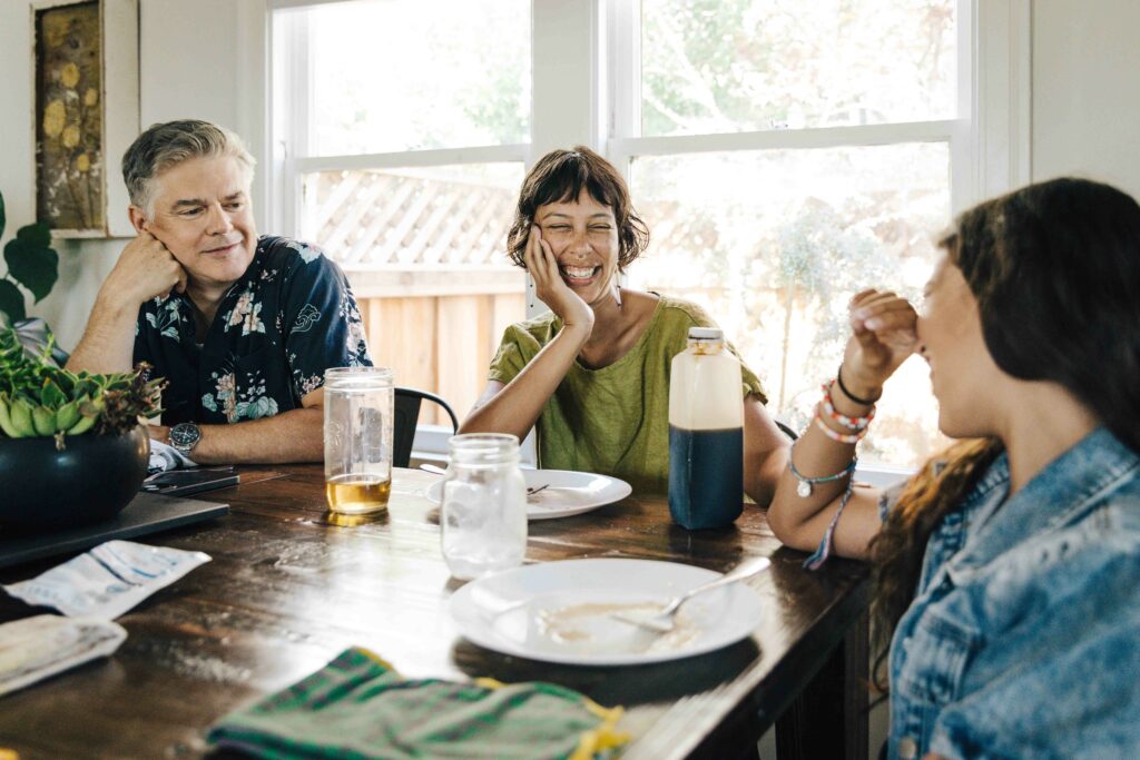 Family laughing at the breakfast table