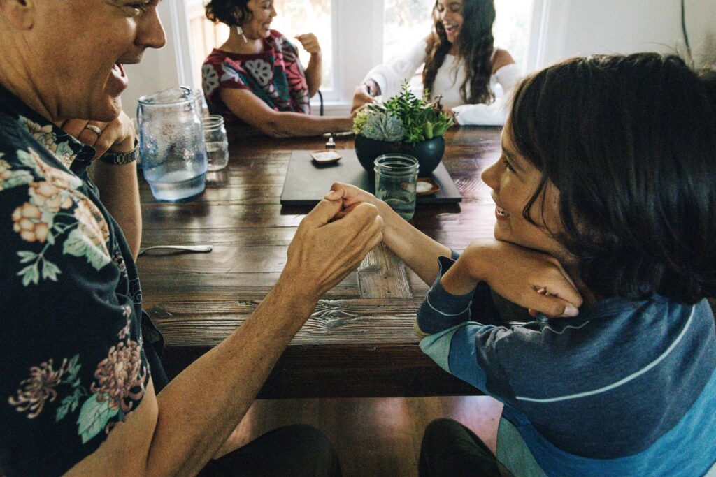 Family playing thumb war during a documentary photo session at home