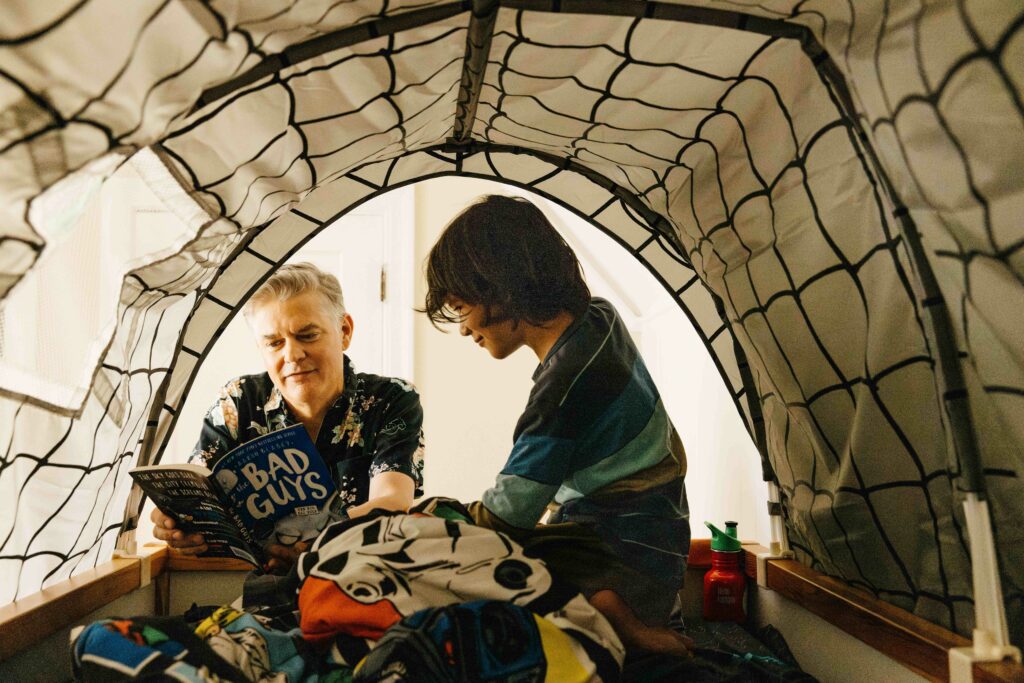 Father reading to young son on the top bunk