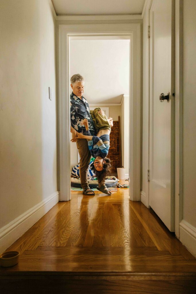 Father holding young son upside down at doorway