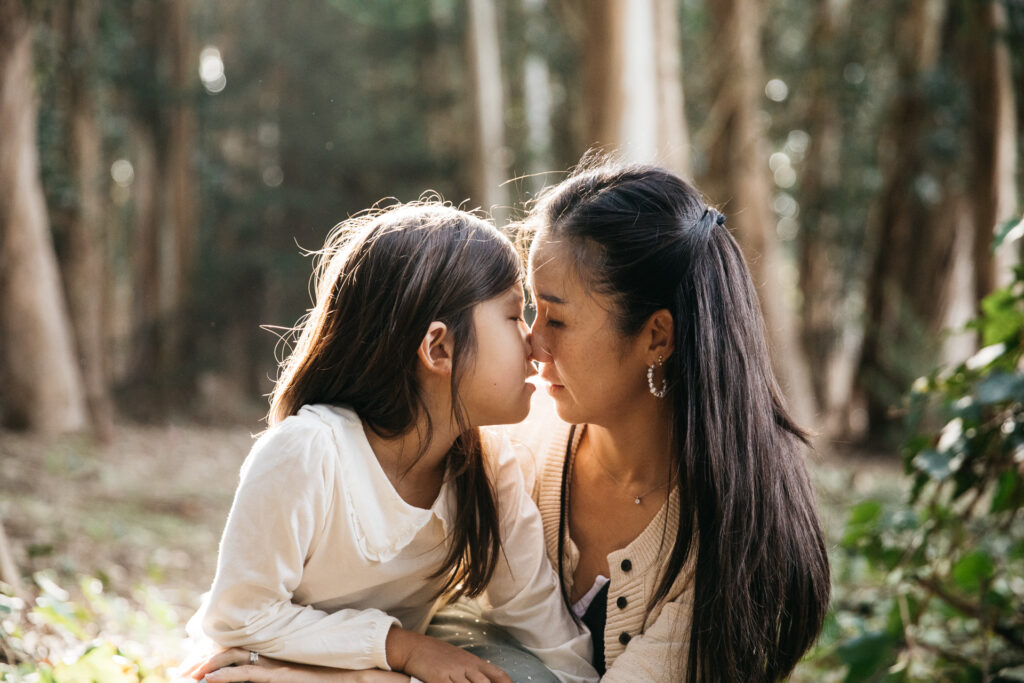 Mother and young daughter sharing a nose kiss during a family session in San Francisco