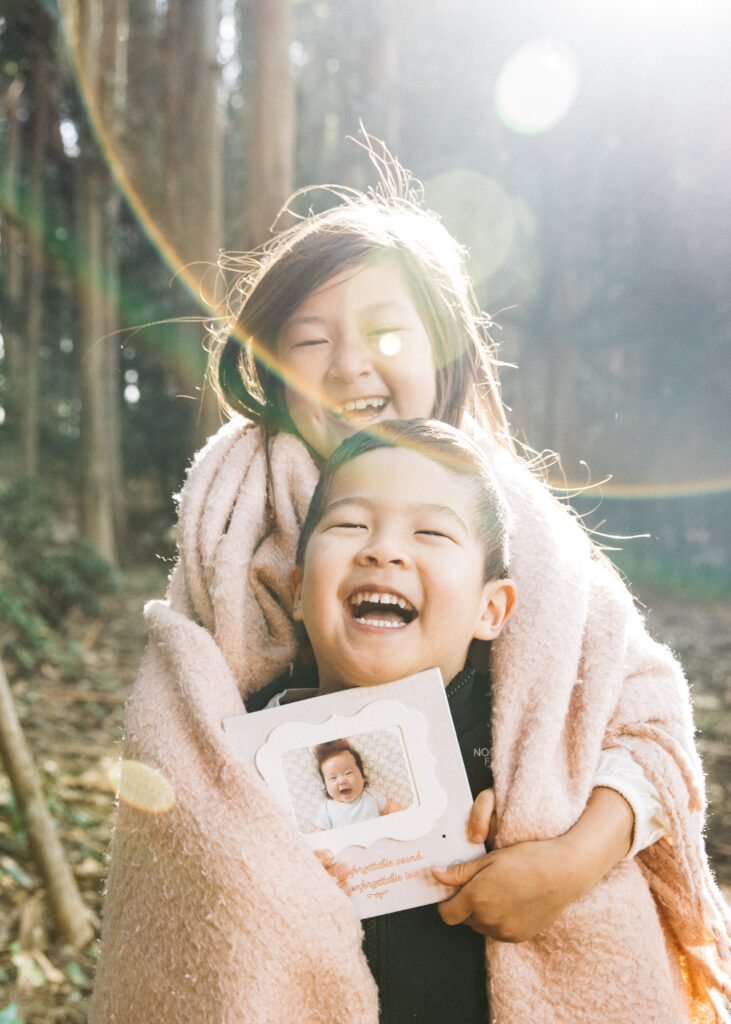 Brother and sister hugging and laughing in the Presidio