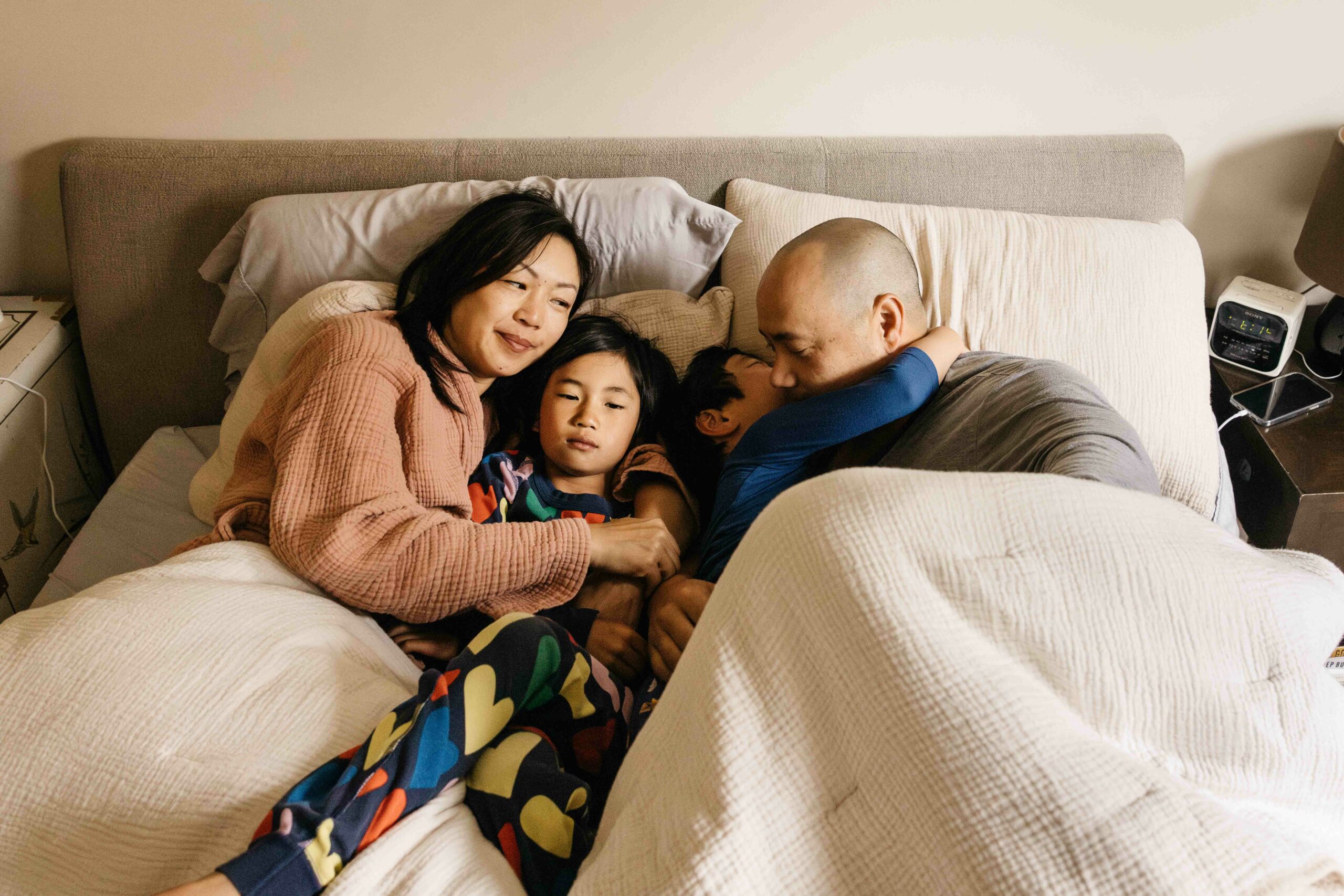 family in pajamas cuddling in bed