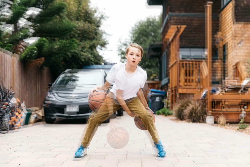 double exposure image of pre-teen boy dribbling a basketball in his backyard