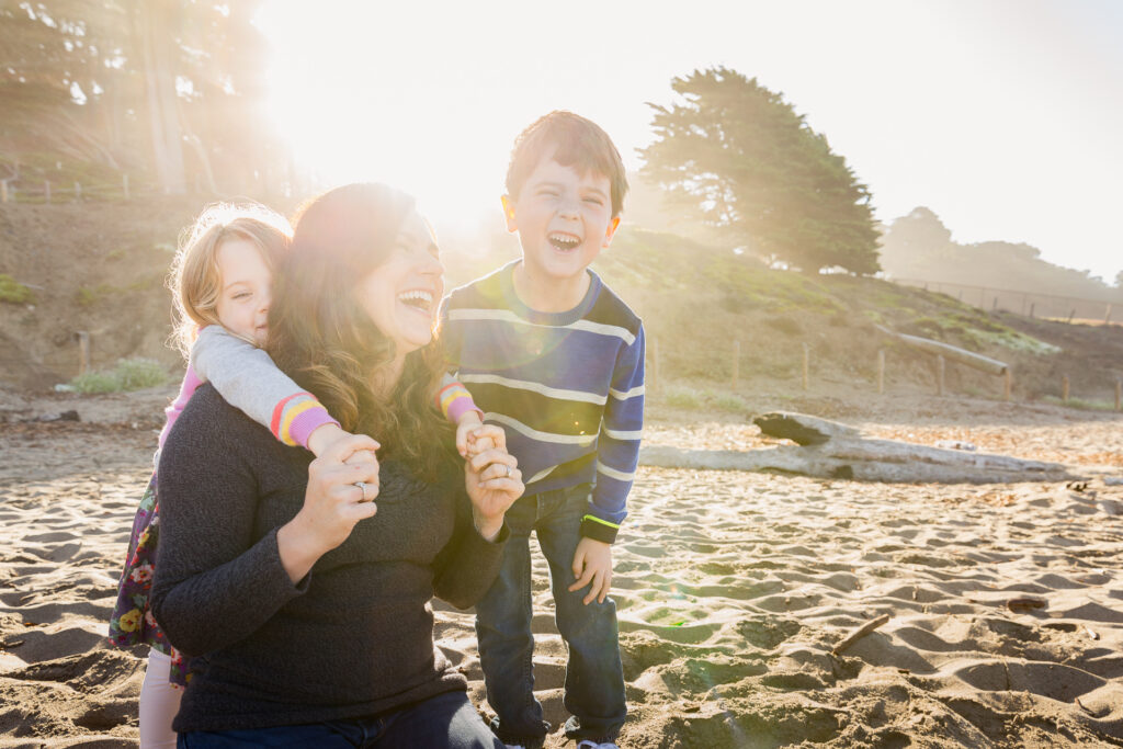 mom laughing with daughter and son at baker beach.