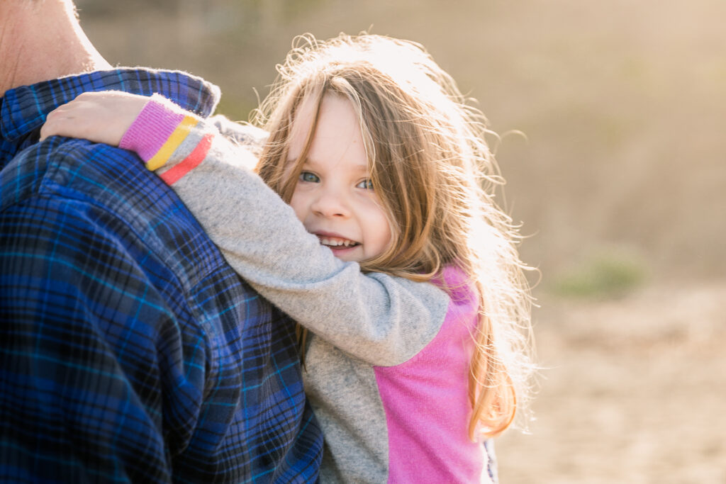 young daughter holding onto her dad's back during a family session in san francisco.