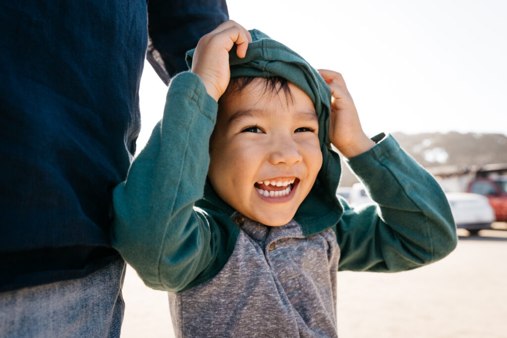 young boy laughing in a hoodie shirt.