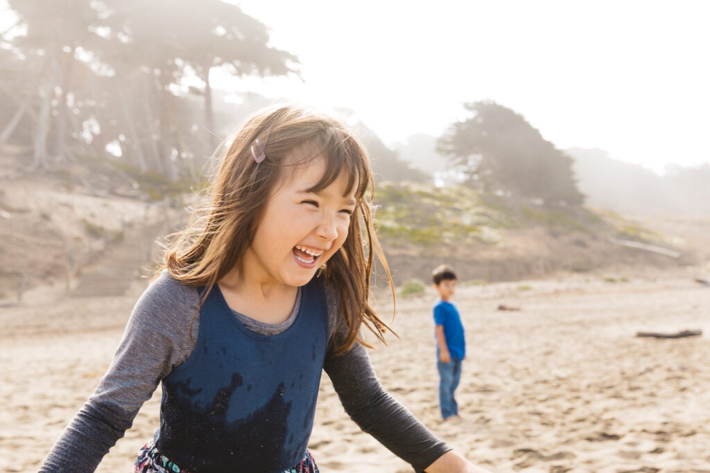 young girl laughing at baker beach.