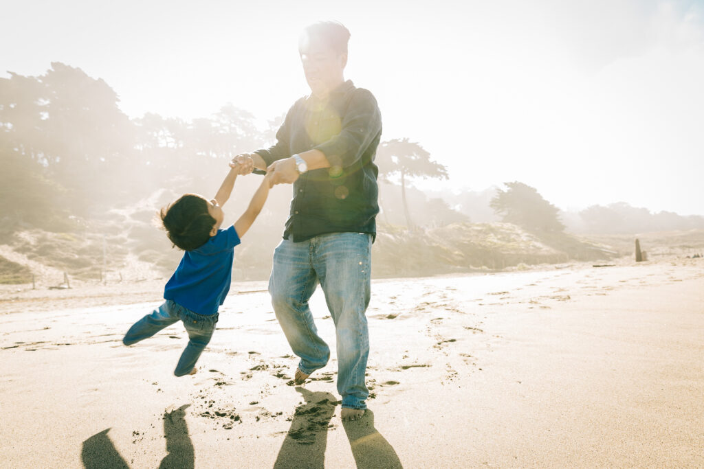 dad throwing his son at baker beach.