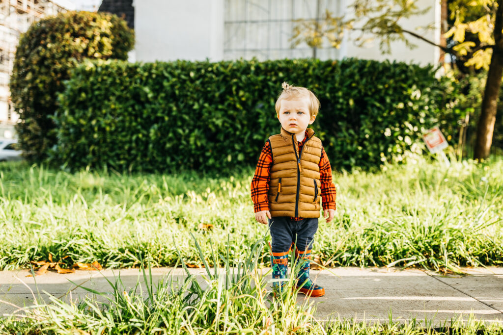 toddler boy looking across the street during a family walk in oakland.