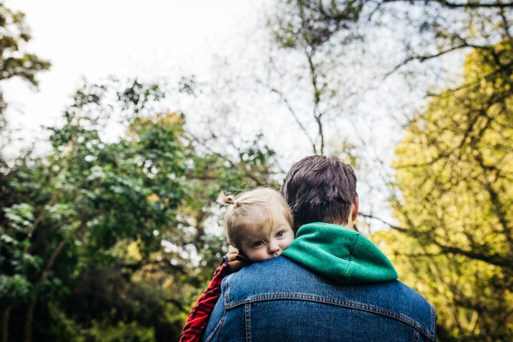 dad carrying young son over his shoulder during a family photo session.