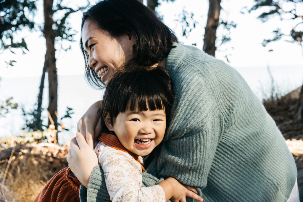 Lots of smiles and laughter as mother and toddler daughter plays.