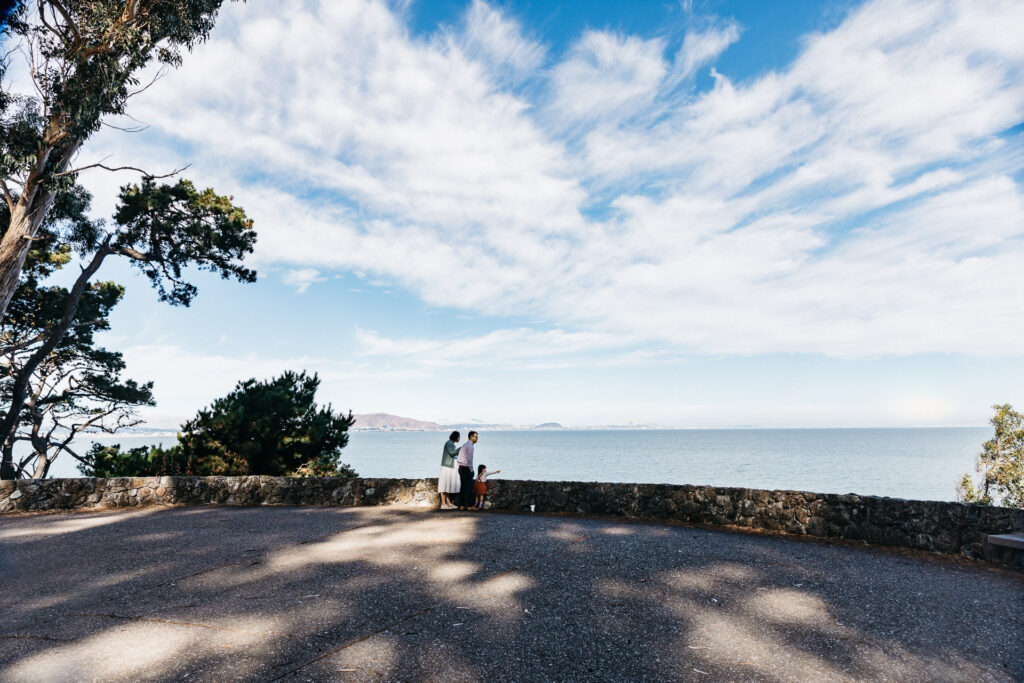 Wide shot of family at an overlook as they view low-flying planes at Coyote Point.