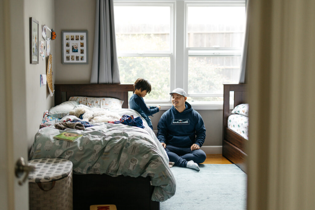 dad playing action figures with toddler son.