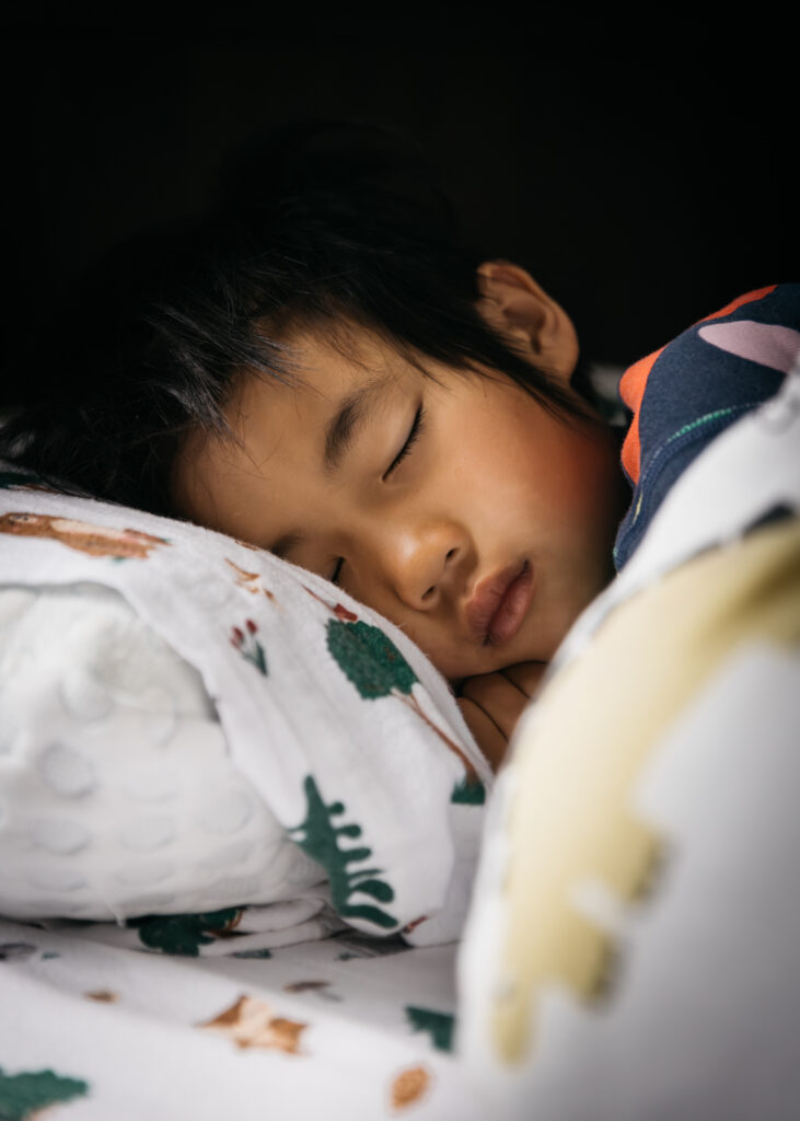 boy sleeping in bed during an at home family photo session in san francisco