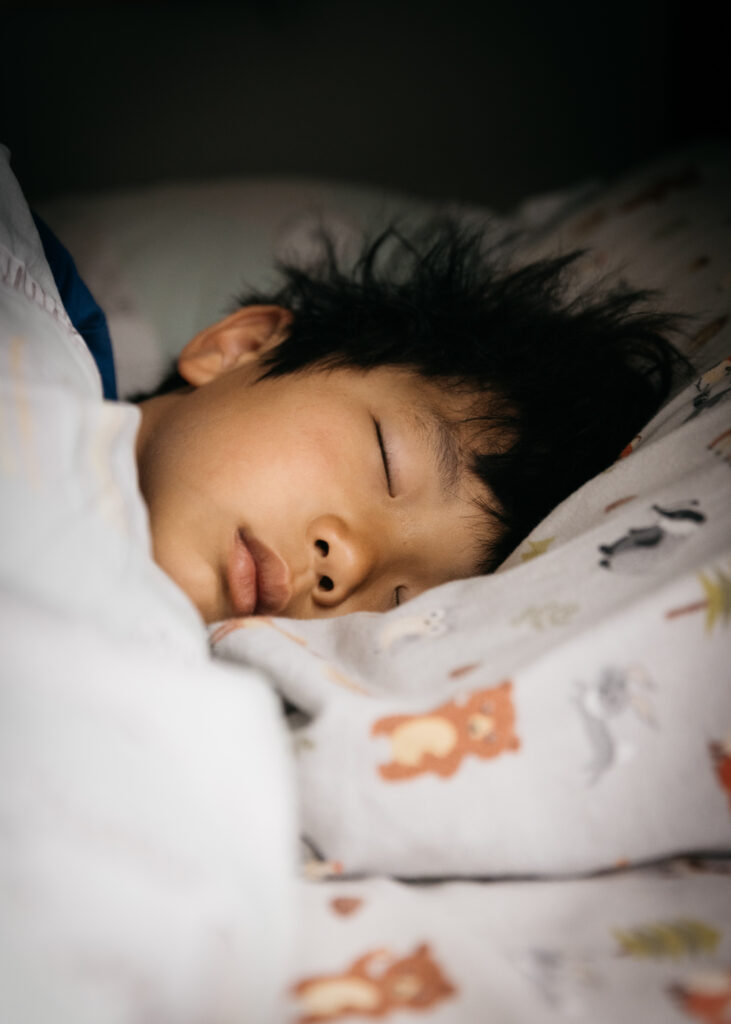 boy sleeping in bed during a day in the life family photo session in san francisco.