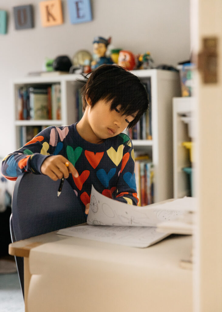 toddler boy drawing in his room during a family photo session in san francisco.