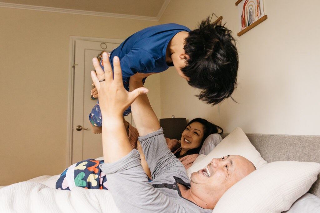 dad throwing his son in the air during a family photo session in san francisco.