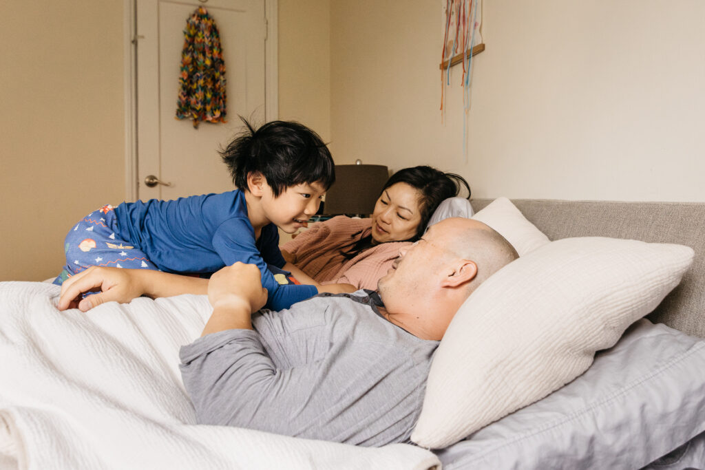 family snuggling during the early morning hours in bed.