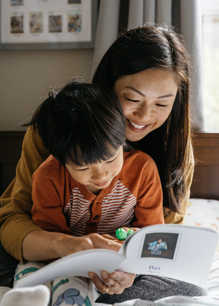 mom reading to toddler son in bed.