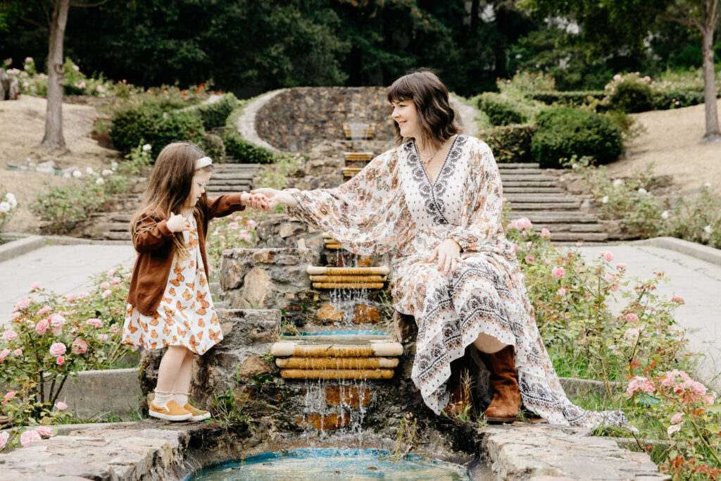 IMG_3841-Oakland-Family-Photographer-Carmen-Dunham-Photography Mom and daughter holding hands at the fountains inside the Oakland Rose Garden.