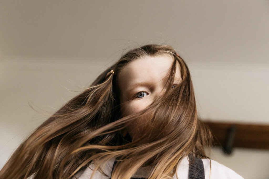 toddler girl hiding behind her hair