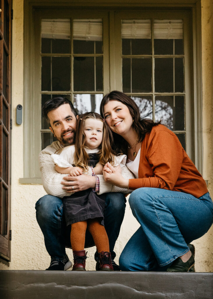 family holding each other on the front porch.