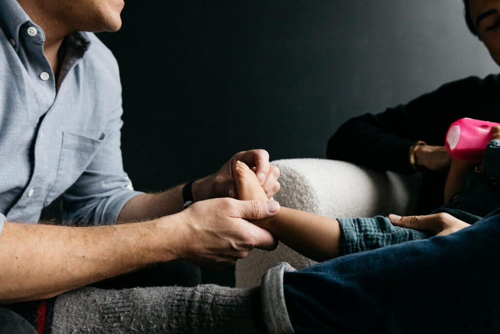 dad tickling his daughter's feet.