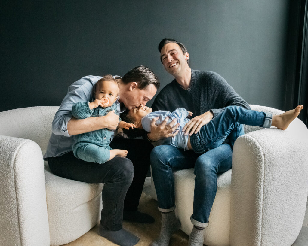family snuggling in chairs during an in-home family session in san francisco.