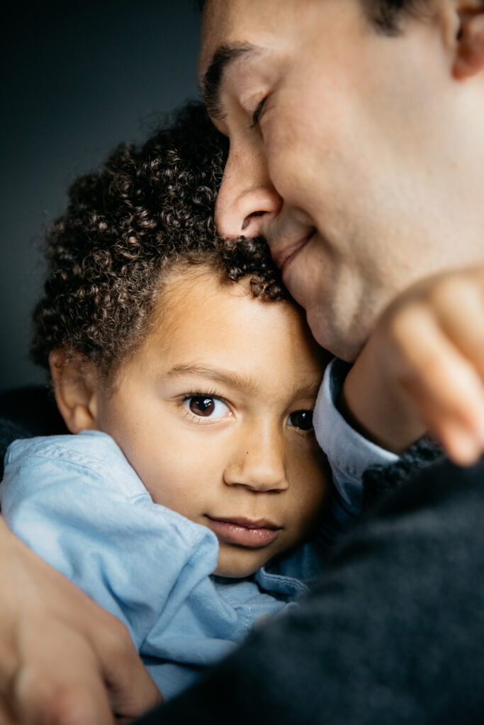 dad snuggling with toddler son during an in-home photo session in san francisco