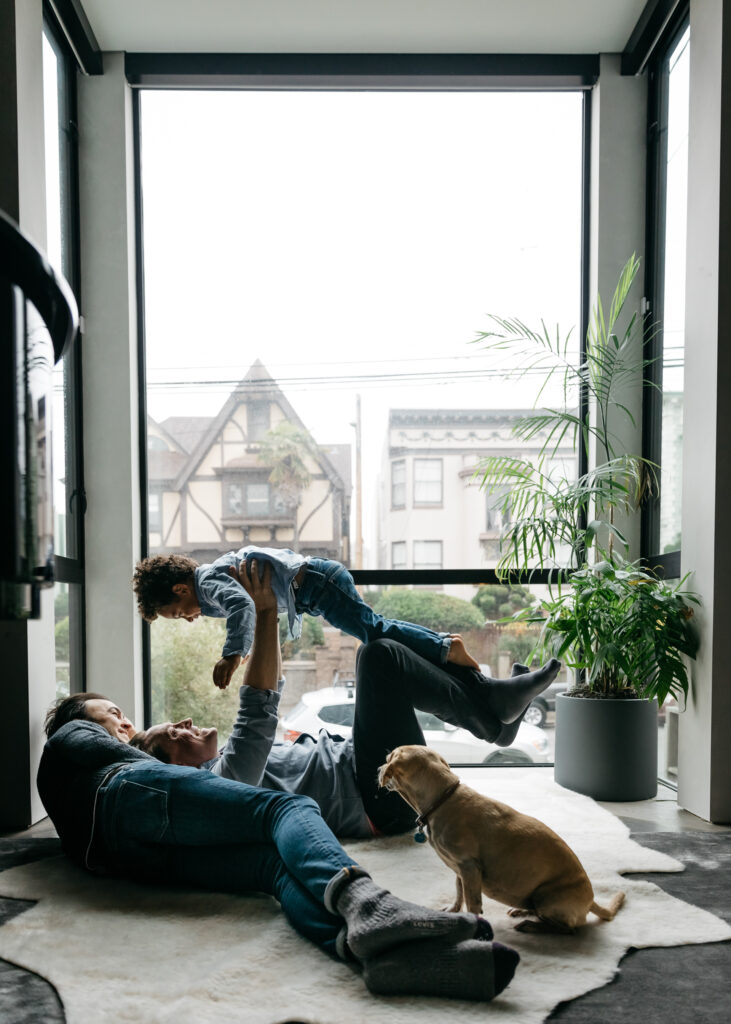 family playing in the box window of living room during an in-home photo session in san francisco