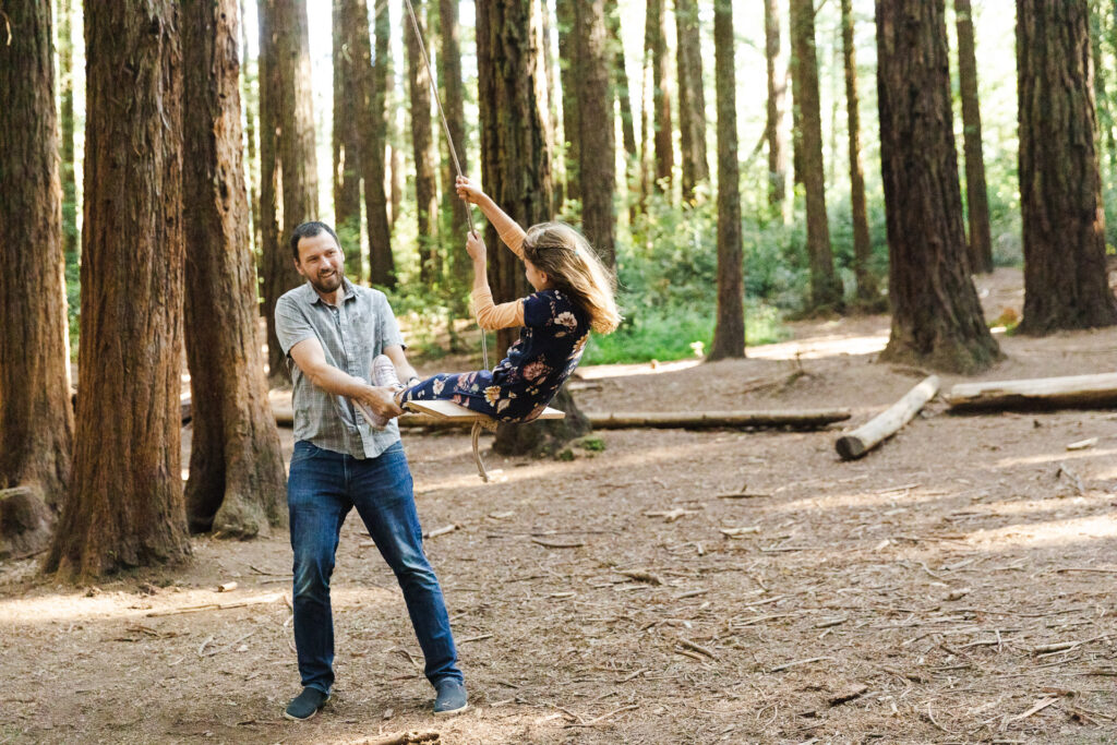 IMG_6789-Oakland-Joaquin-Miller-Family-Photography-Session-Carmen-Dunham-Photography Dad pushing daughter on a rope swing at Joaquin Miller Park.
