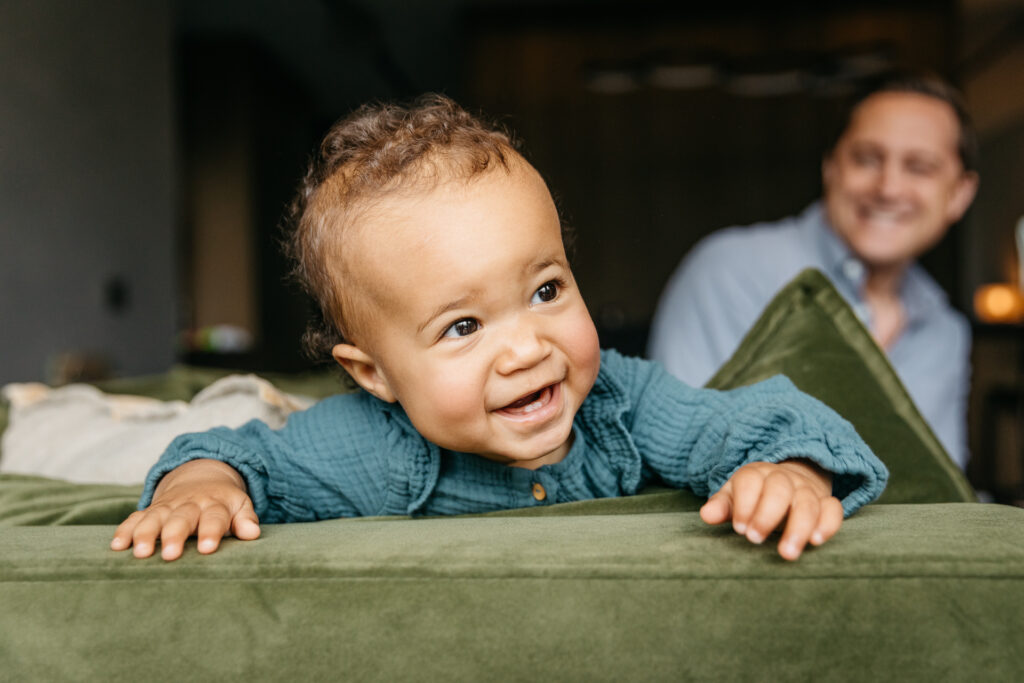 young toddler girl climbing on the sofa