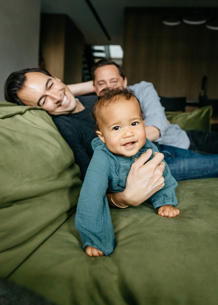 family cuddling on the sofa during an in-home family photo session in san francisco.