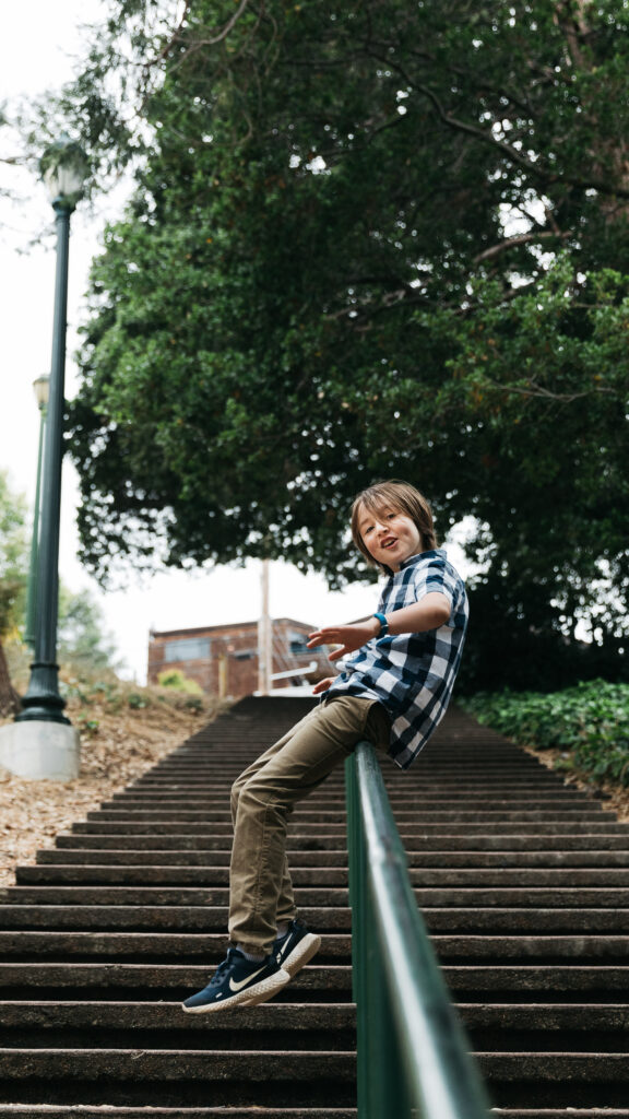IMG_8549-Oakland-Family-Photographer-Carmen-Dunham-Photography Young boy sliding on a handrail at the Oakland Rose Garden.