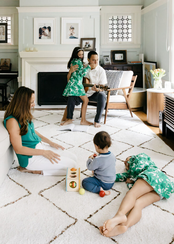 The whole family is leisurely hanging out in the living room together.
