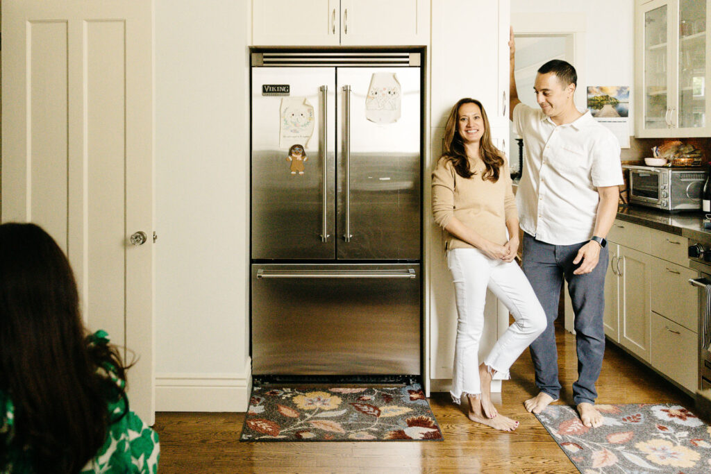 Mom and dad are hanging out in the kitchen as their kids have a snack.
