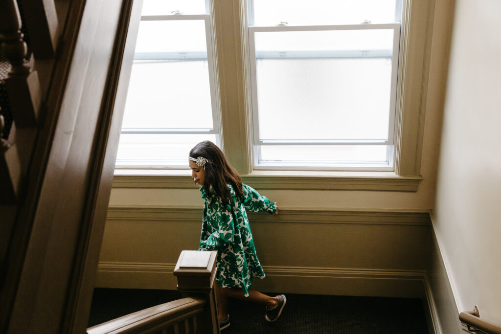 Girl is racing down the stairs of her apartment building.