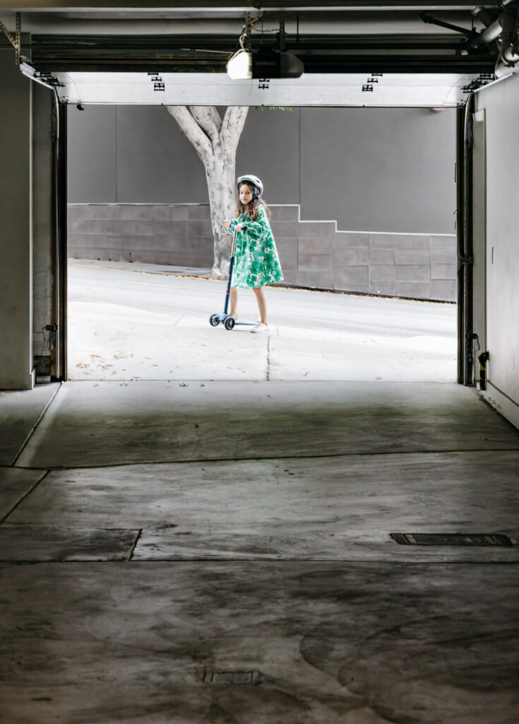 Nine year old girl is scooting on her scooter on a steep hill in San Francisco.