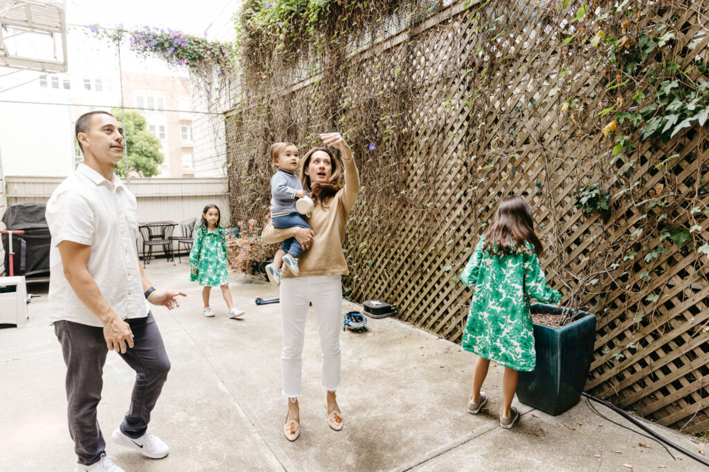 Family plays basketball in the backyard.