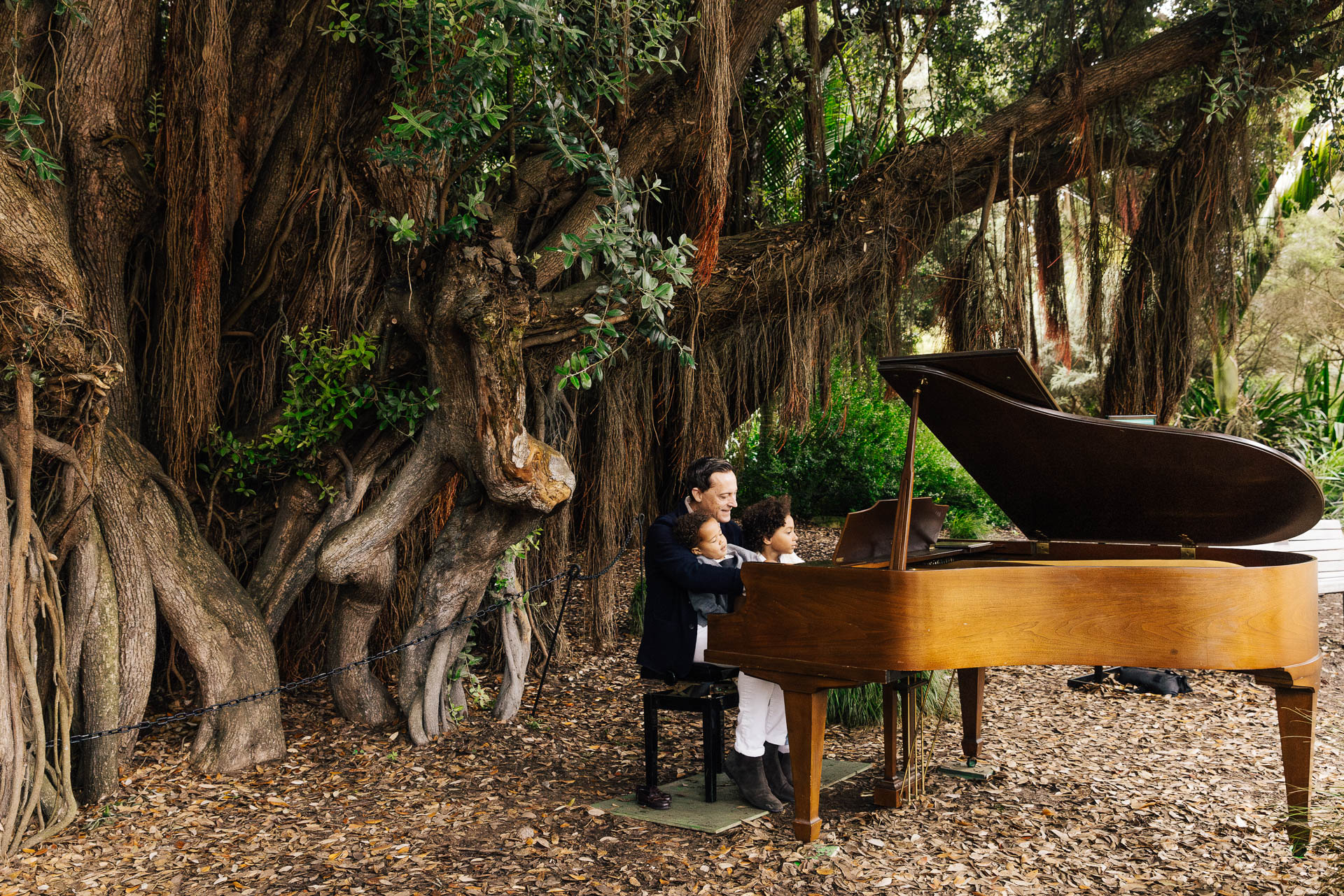 Dad playing the piano with kids on his lap during Flower Piano at Golden Gate Park.