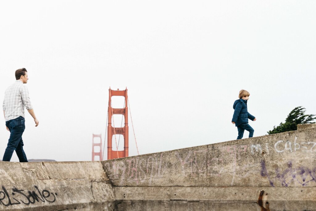 Father and son playing at Battery Boutelle with the Golden Gate Bridge peeking in the background.