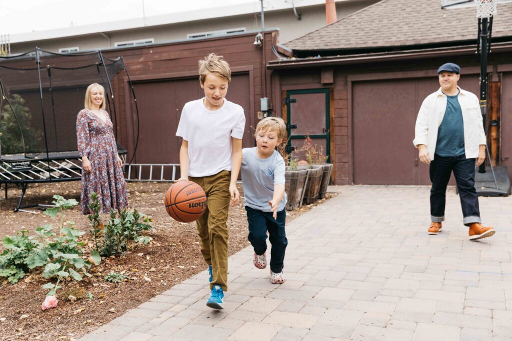 family playing basketball in their backyard.
