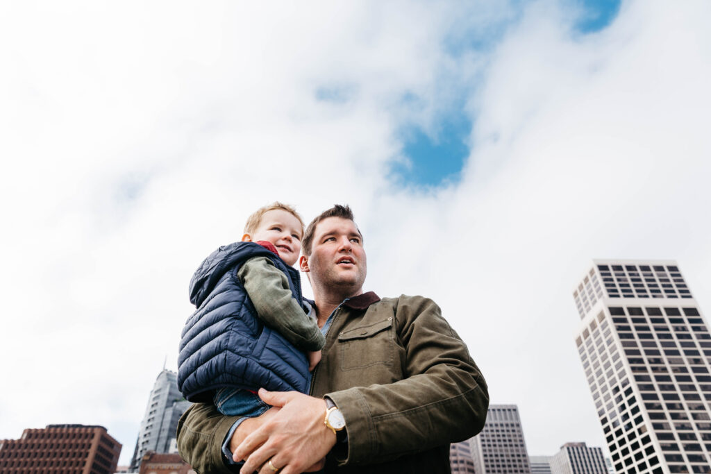Dad holding young son with skyscrapers in the background