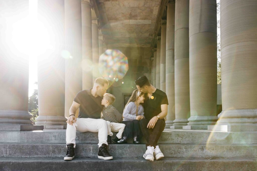 Dads kissing their kids on the steps of the Music Concourse