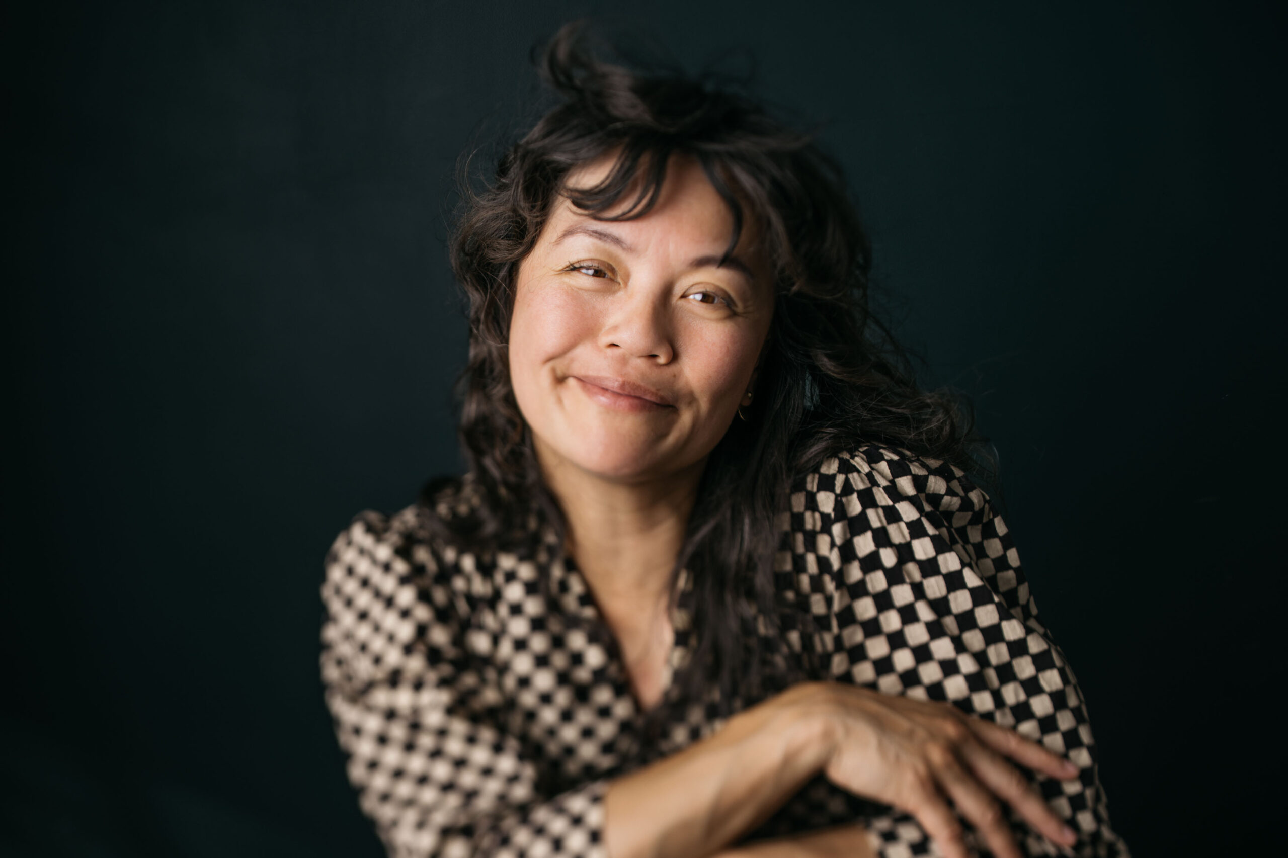 BIPOC asian woman photographer smiling warmly at camera